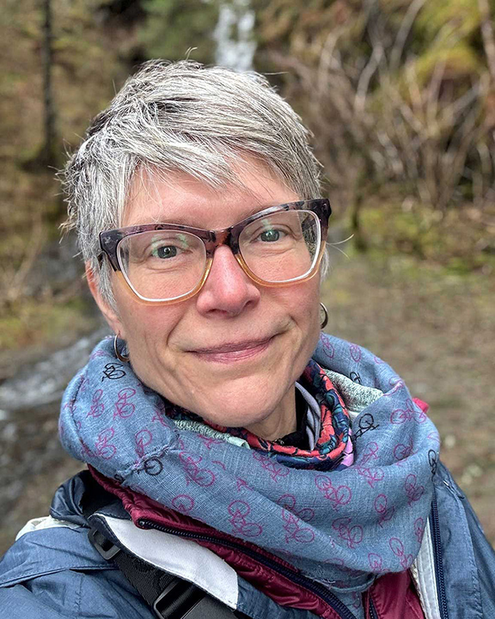 A photo of Sarah Allen in front of a waterfall in Seward, AK